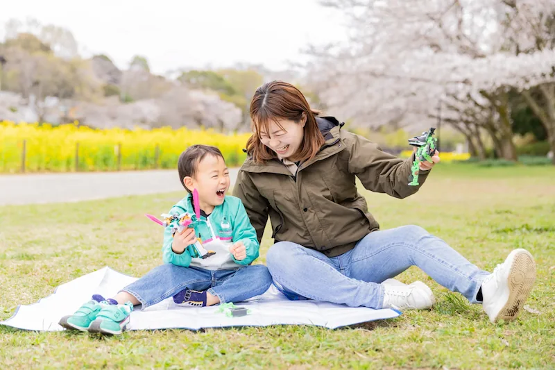 出張撮影で親子が芝生の上に座って楽しく会話する様子