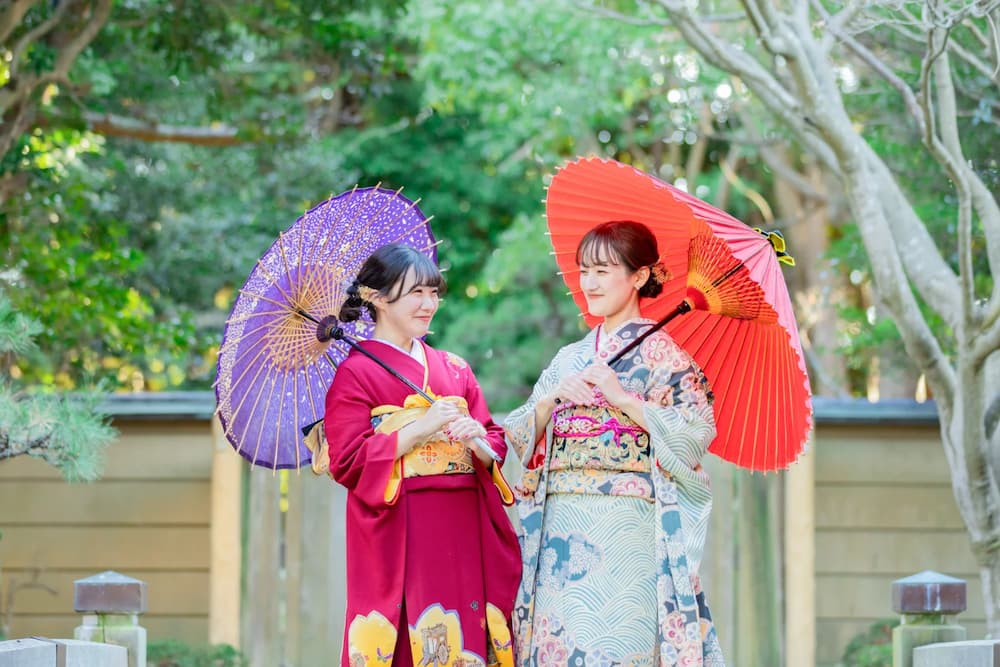 和傘を持ってご成人祝いの撮影をする友人同士の女性
