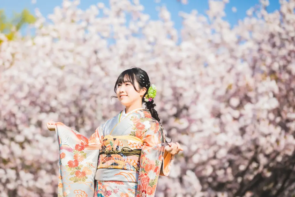 桜をバックに振袖を着て成人記念撮影
